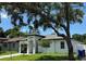 Contemporary single-Gathering home with manicured lawn and mature shade tree in the front yard at 7208 N Glen Ave, Tampa, FL 33614