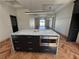 Kitchen island with granite countertop, stainless steel microwave and wood flooring at 7208 N Glen Ave, Tampa, FL 33614