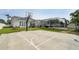 Spacious backyard featuring a basketball court and screened-in patio area at 750 Sand Pine Ne Dr, St Petersburg, FL 33703