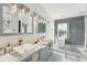 Modern bathroom featuring a double vanity sink, and a shower and soaking tub with stone-style floor tiles at 750 Sand Pine Ne Dr, St Petersburg, FL 33703
