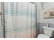 Stylish bathroom featuring a patterned shower curtain, muted tile, and a decorative piece of artwork at 750 Sand Pine Ne Dr, St Petersburg, FL 33703