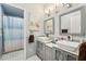 Stylish bathroom featuring a double sink vanity, modern lighting, and a walk-in shower with a patterned curtain at 750 Sand Pine Ne Dr, St Petersburg, FL 33703
