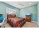 Bright bedroom featuring a large window, ceiling fan, TV, and dark wood bed frame, creating an inviting space at 750 Sand Pine Ne Dr, St Petersburg, FL 33703