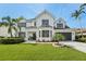 Elegant two-story home with lush lawn, manicured landscaping and paver driveway at 750 Sand Pine Ne Dr, St Petersburg, FL 33703