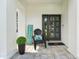 Cozy front porch with welcome sign, chair, and potted plant at 750 Sand Pine Ne Dr, St Petersburg, FL 33703