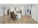 Bright kitchen features white cabinets, stainless appliances, a large island with seating, and light-colored wood flooring at 750 Sand Pine Ne Dr, St Petersburg, FL 33703