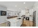 A modern, white kitchen features an island with seating and stainless steel appliances for a clean and functional design at 750 Sand Pine Ne Dr, St Petersburg, FL 33703