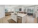 The spacious modern kitchen features white cabinets, marble countertops, stainless steel appliances and view to outdoor dining at 750 Sand Pine Ne Dr, St Petersburg, FL 33703