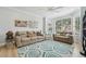 Bright living room with large window, neutral colored furniture, and decorative rug at 750 Sand Pine Ne Dr, St Petersburg, FL 33703