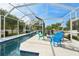 Screened-in pool area with seating, fire pit, and view of landscaped backyard at 750 Sand Pine Ne Dr, St Petersburg, FL 33703