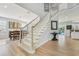 Bright foyer with staircase leading to the second floor, light wood floors, and view to dining and pool area at 750 Sand Pine Ne Dr, St Petersburg, FL 33703