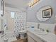 Bathroom with tub/shower, updated vanity with white marble top, and nautical themed decor at 7714 Bayleaf Dr, Hudson, FL 34667