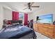 Bedroom with a ceiling fan, TV, natural light and a playful car-themed comforter set at 7714 Bayleaf Dr, Hudson, FL 34667