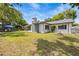 Charming home showcasing a well-maintained backyard, screened porch, and mature landscaping at 7714 Bayleaf Dr, Hudson, FL 34667