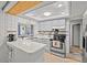 Bright kitchen with stainless steel appliances, white cabinets, and a convenient breakfast bar at 7714 Bayleaf Dr, Hudson, FL 34667