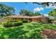 Charming single-story home with a well-manicured lawn, mature landscaping, and an inviting entryway at 785 Hickory Ln, Palm Harbor, FL 34683