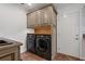 Laundry room features updated appliances, overhead cabinets, and a tile floor at 785 Hickory Ln, Palm Harbor, FL 34683