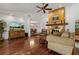 Bright living room with hardwood floors, stone fireplace, high ceilings, and large TV at 785 Hickory Ln, Palm Harbor, FL 34683