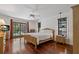 Main bedroom features wood flooring, a ceiling fan and french doors to pool area at 785 Hickory Ln, Palm Harbor, FL 34683