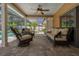 Relaxing covered patio with wicker furniture, ceiling fan and view of the pool area at 785 Hickory Ln, Palm Harbor, FL 34683