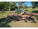 Community playground with slides and climbing features is surrounded by greenery and mulch at 785 Hickory Ln, Palm Harbor, FL 34683
