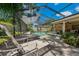 Inviting screened-in pool area featuring lounge chairs and a covered patio for relaxing and entertaining at 785 Hickory Ln, Palm Harbor, FL 34683