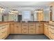 A double vanity bathroom with traditional style cabinetry, granite countertop, and decorative framed mirrors at 8030 Manasota Key Rd, Englewood, FL 34223