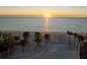 Scenic beach view with palm trees and calm ocean waters under a warm sunset at 8030 Manasota Key Rd, Englewood, FL 34223