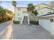 Charming multi-level home with a brick driveway, staircase, and well-maintained landscaping at 8030 Manasota Key Rd, Englewood, FL 34223