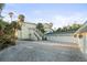 Beachfront home featuring lush landscaping, an attached three car garage, and circular driveway at 8030 Manasota Key Rd, Englewood, FL 34223