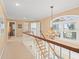 Hallway landing with staircase, chandelier, and arched transom window offering natural light at 8030 Manasota Key Rd, Englewood, FL 34223