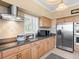 Bright kitchen featuring stainless appliances and tan cabinets, with tiled backsplash at 8030 Manasota Key Rd, Englewood, FL 34223