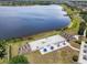 Community beach volleyball area with seating, and umbrella table area overlooking the lake at 10742 Verawood Dr, Riverview, FL 33579