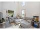 Cozy living room with grey sectional sofa, area rug, and sliding glass doors at 10742 Verawood Dr, Riverview, FL 33579