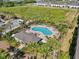 Aerial view of the community pool area with palm trees, lounge chairs, and a nearby playground at 10742 Verawood Dr, Riverview, FL 33579