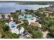 Aerial view of a large community pool area featuring multiple pools, a playground, and lake views at 10742 Verawood Dr, Riverview, FL 33579
