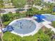 Aerial view of community splash pad with colorful play structures, seating area, and surrounded by landscaping at 10742 Verawood Dr, Riverview, FL 33579