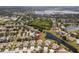 Aerial view showcasing the property's location, surrounded by lush greenery, community pond, and other homes at 11466 Captiva Kay Dr, Riverview, FL 33569