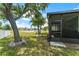 Landscaped backyard offers a serene lake view and a screened patio for outdoor gatherings at 11466 Captiva Kay Dr, Riverview, FL 33569