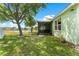 Spacious backyard with lush green grass, mature trees, and a serene lake view at 11466 Captiva Kay Dr, Riverview, FL 33569
