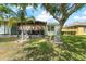 Backyard showing well-maintained lawn, privacy hedges, and screened patio for outdoor relaxation at 11466 Captiva Kay Dr, Riverview, FL 33569