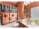 Bright bathroom features a vanity with sink, peach walls, and a colorful shower curtain at 11466 Captiva Kay Dr, Riverview, FL 33569