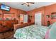 Spacious bedroom with a large bed, patterned bedding, hard wood floors, and practical exercise equipment at 11466 Captiva Kay Dr, Riverview, FL 33569