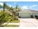 Charming light green single-story home with lush landscaping, rock garden and a well-manicured lawn at 11466 Captiva Kay Dr, Riverview, FL 33569