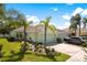 Charming light green single-story home with lush landscaping, rock garden and a well-manicured lawn at 11466 Captiva Kay Dr, Riverview, FL 33569