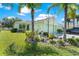 Charming light green single-story home with lush landscaping and a well-manicured lawn at 11466 Captiva Kay Dr, Riverview, FL 33569