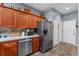 Well-lit kitchen with stainless steel appliances, wooden cabinets, and a tiled backsplash, great for cooking at 11466 Captiva Kay Dr, Riverview, FL 33569