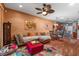 Inviting living room with a sectional sofa, colorful rug, and decorative ceiling fan, ideal for relaxation at 11466 Captiva Kay Dr, Riverview, FL 33569