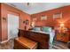 Bedroom featuring wood floors, an earth-tone color scheme, and bedside tables with lamps at 11466 Captiva Kay Dr, Riverview, FL 33569