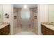 Well-lit bathroom featuring dual vanities, stone countertops, and a large, shared walk-in shower at 11506 Harbourside Ln, Parrish, FL 34219
